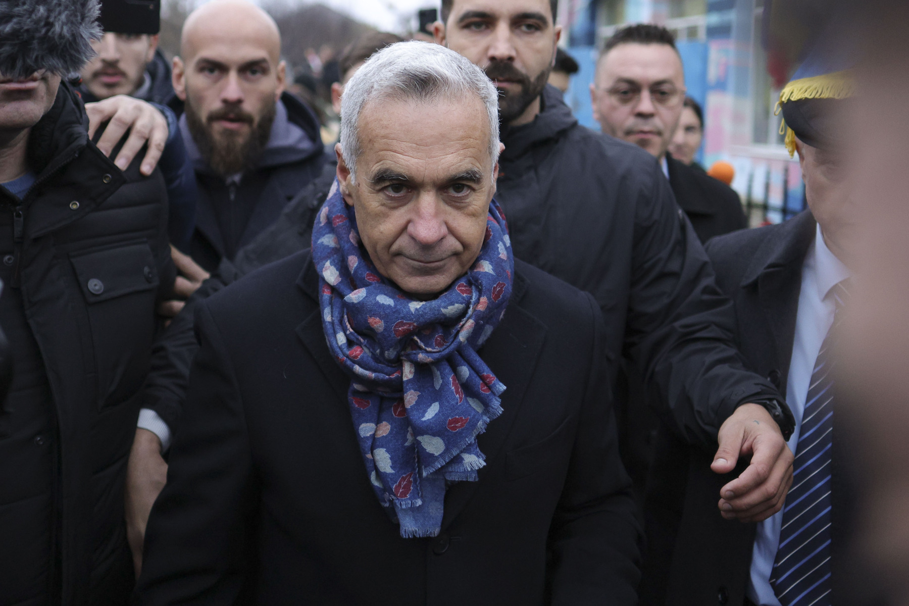 Călin Georgescu flancat de agenți de pază